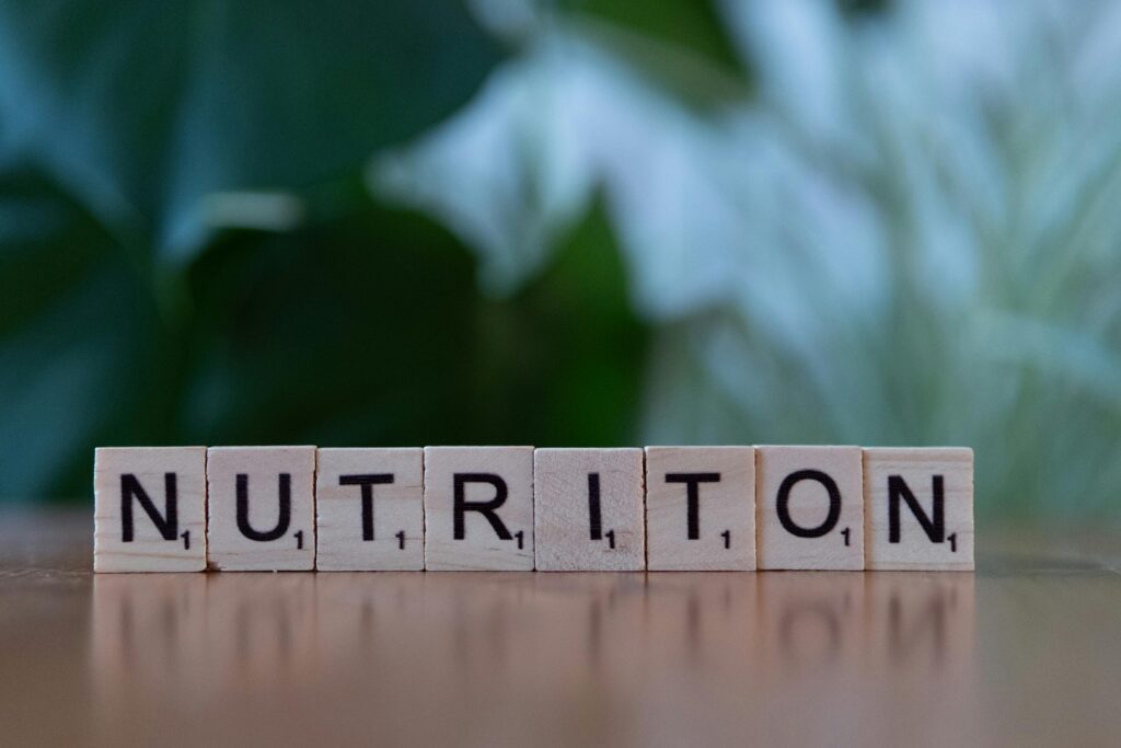 Wooden tiles spelling 'nutrition' on a table with blurred background.